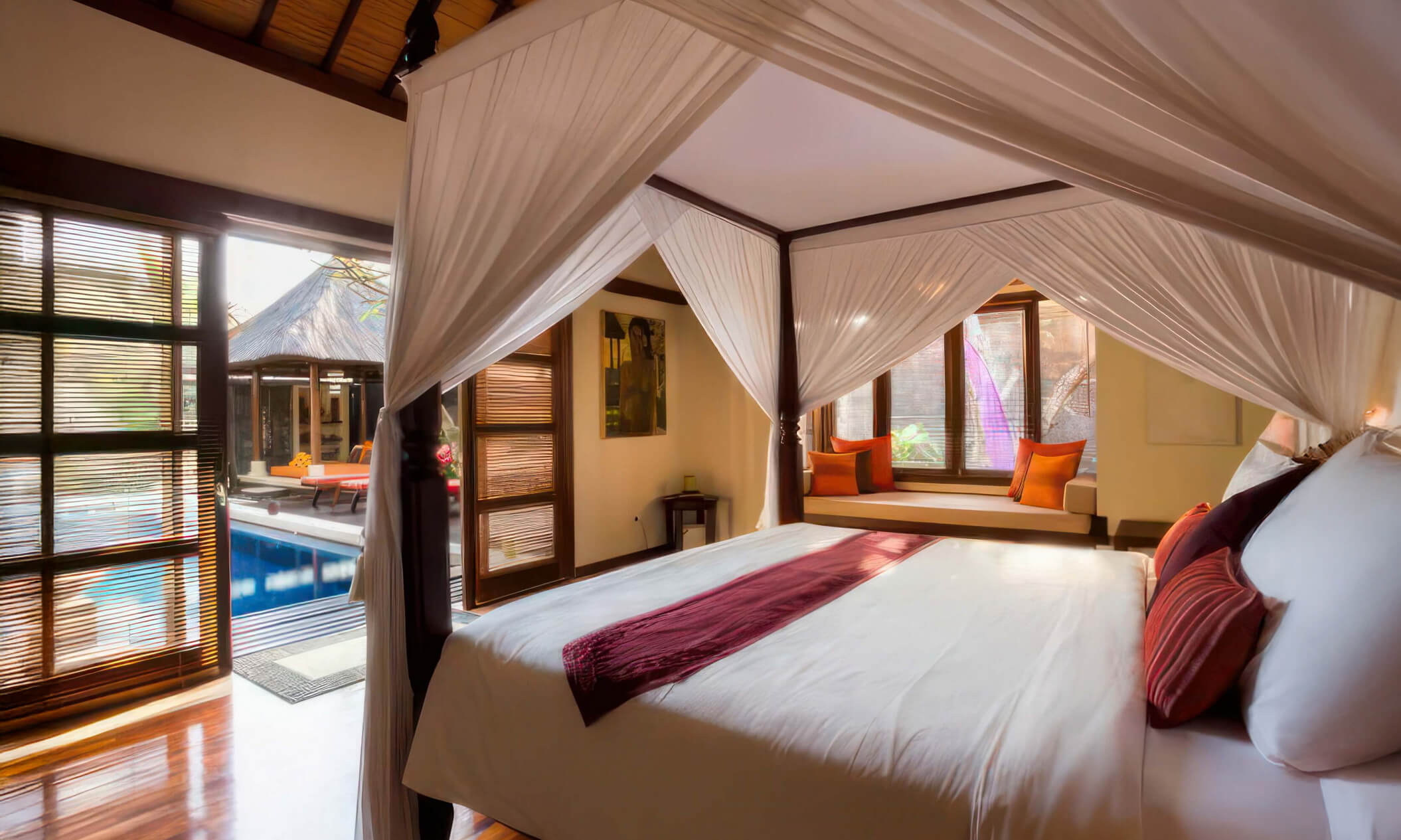 Master bedroom with a four-poster king bed, sunlit daybed and direct pool access