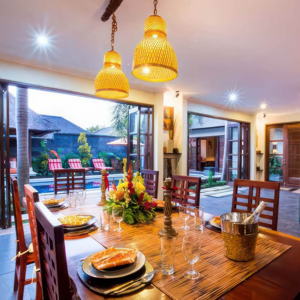 Open French doors connecting the dining table to Villa Saffron’s pool