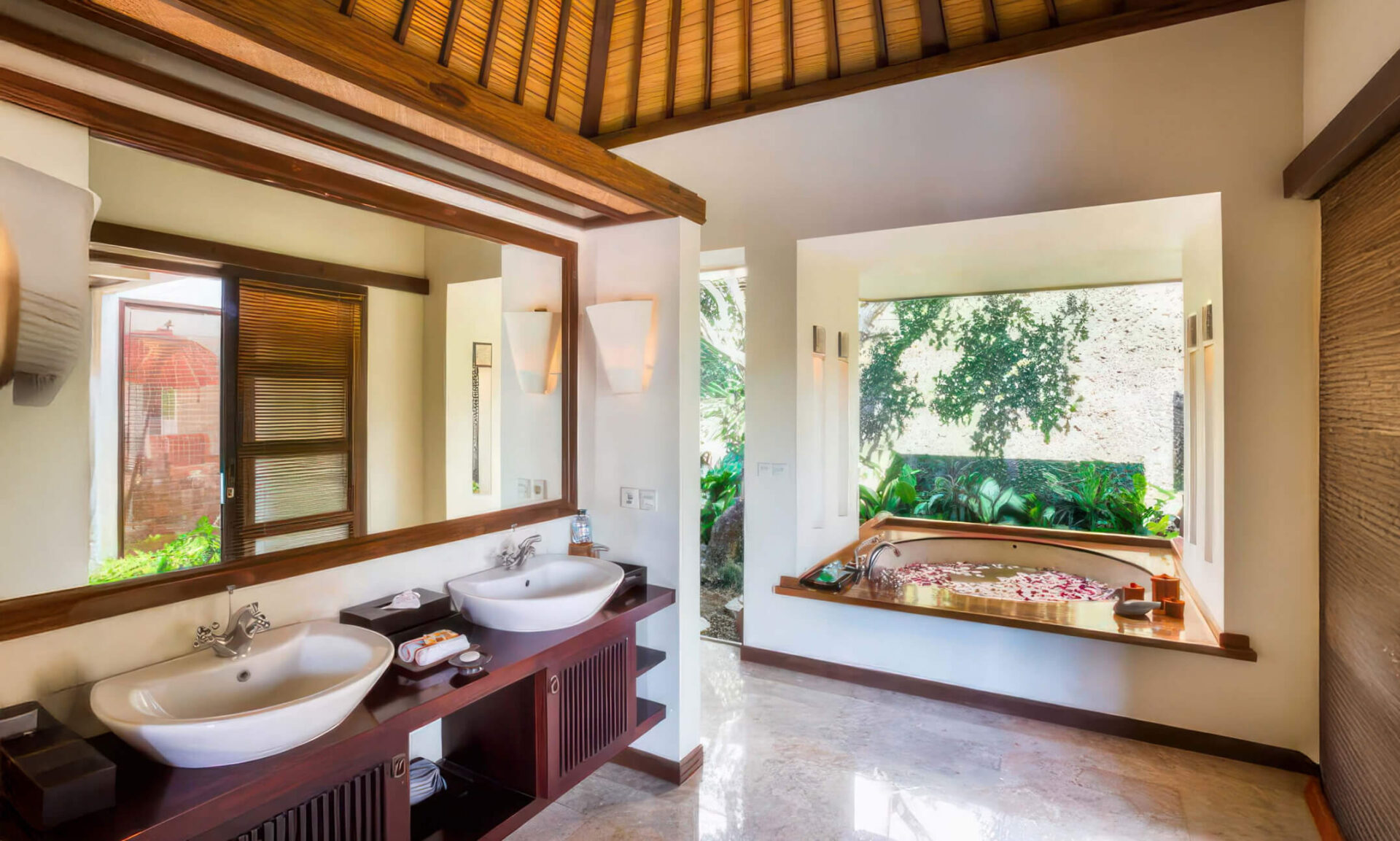 Master bathroom with twin sinks and a circular bath beside a private garden